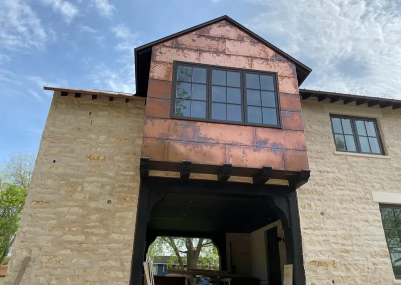 Copper metal panel facade on a stone building for Roof Repair in Jerome